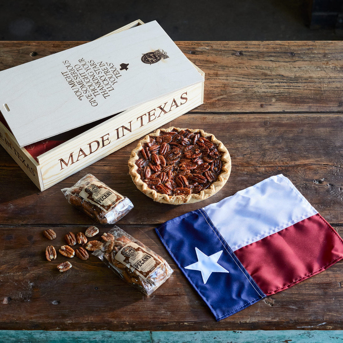 Made in Texas wooden pie box, fresh pecan pie, bags of open pralines, Texas state flag. 