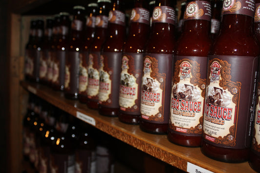 A row of Goode Company Heavy Garlic bbq sauce bottles