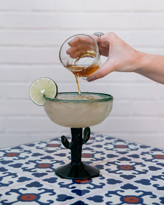  A narrow photo of a margarita glass with a lime and salted rim